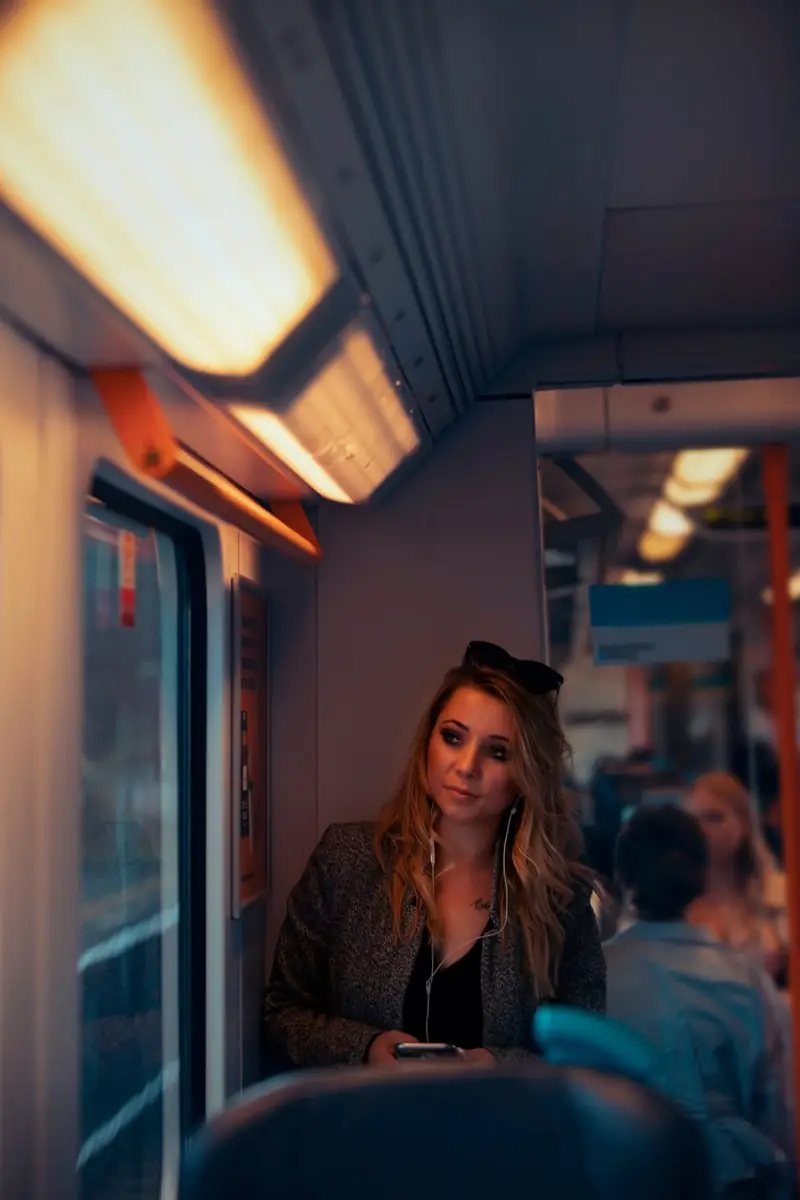 A woman with headphones on a train
