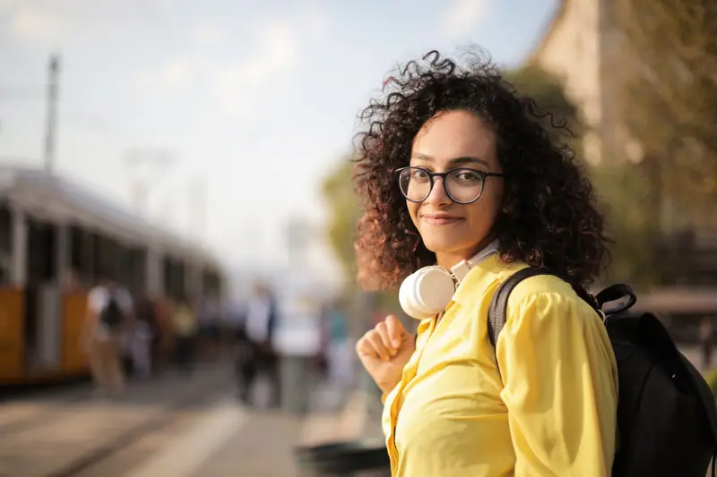 A woman with headphones at a train station