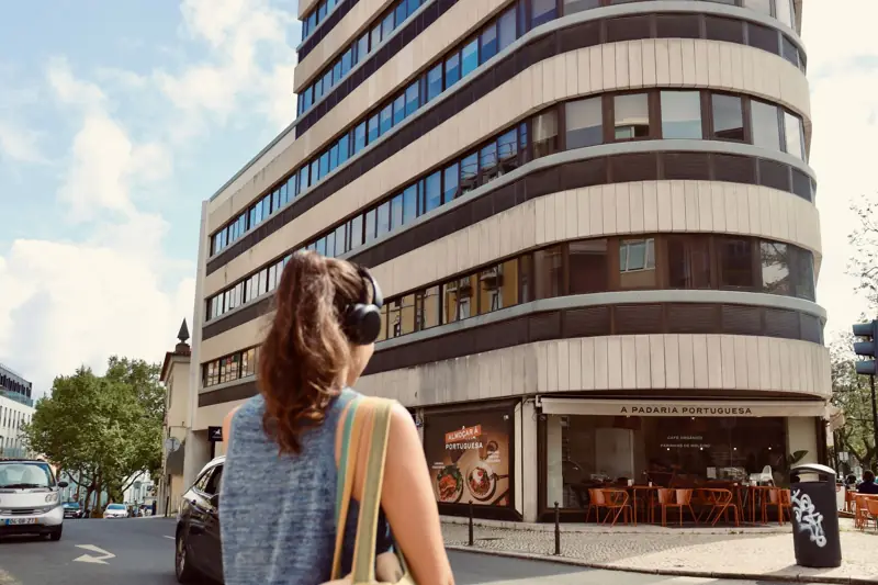 A woman with headphones walking in a city